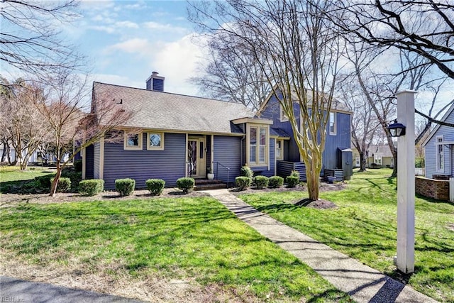 view of front of home featuring a chimney, a front lawn, and roof with shingles