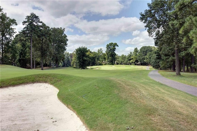 view of community featuring golf course view and a lawn