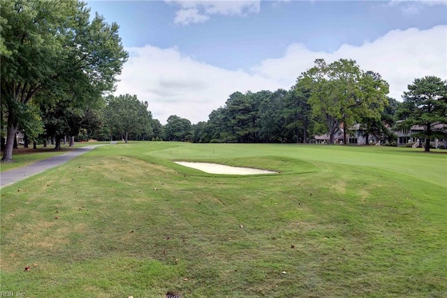 view of community featuring a yard and view of golf course