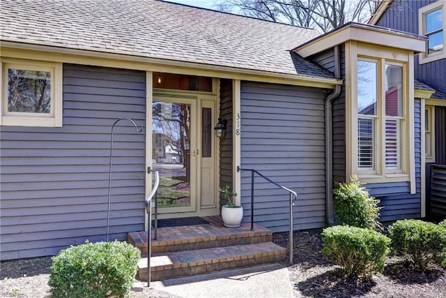 property entrance featuring a shingled roof