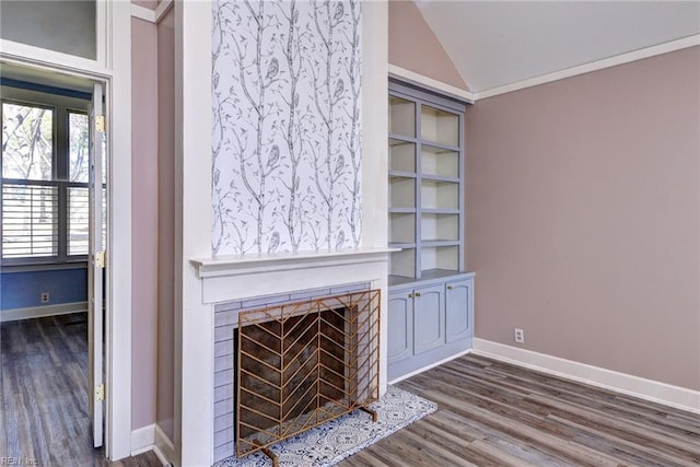 unfurnished living room with vaulted ceiling, a fireplace with flush hearth, dark wood-style floors, and baseboards