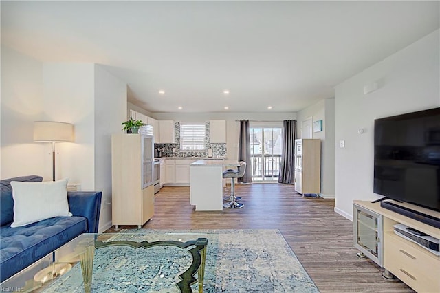 living area with recessed lighting, baseboards, and light wood-style floors