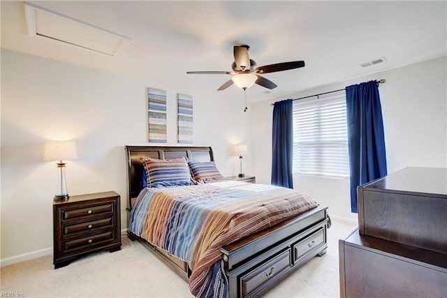 bedroom with visible vents, baseboards, light colored carpet, and attic access