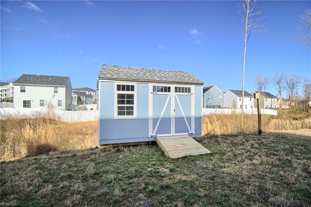 view of shed with fence and a residential view