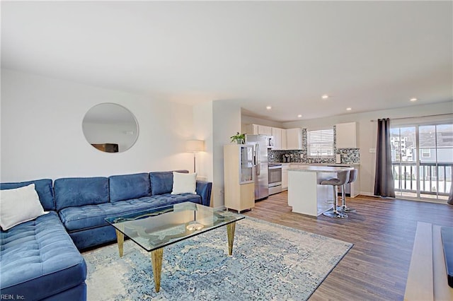 living area featuring recessed lighting, light wood-style flooring, and baseboards