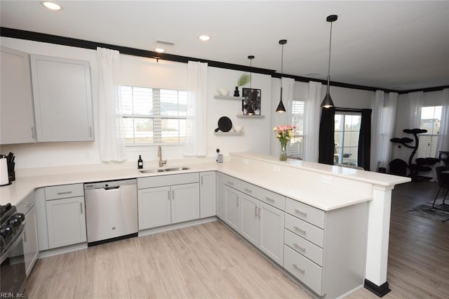 kitchen featuring black gas range oven, crown molding, a peninsula, stainless steel dishwasher, and a sink