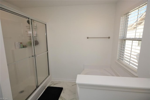 full bath with marble finish floor, a shower stall, and a healthy amount of sunlight