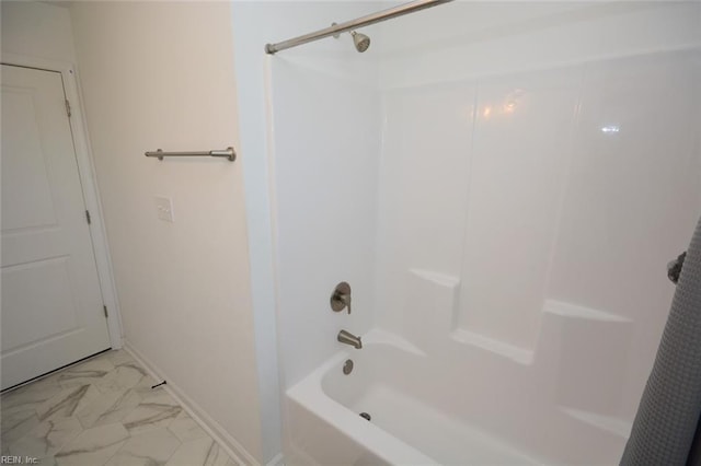 bathroom with shower / bathing tub combination, baseboards, and marble finish floor