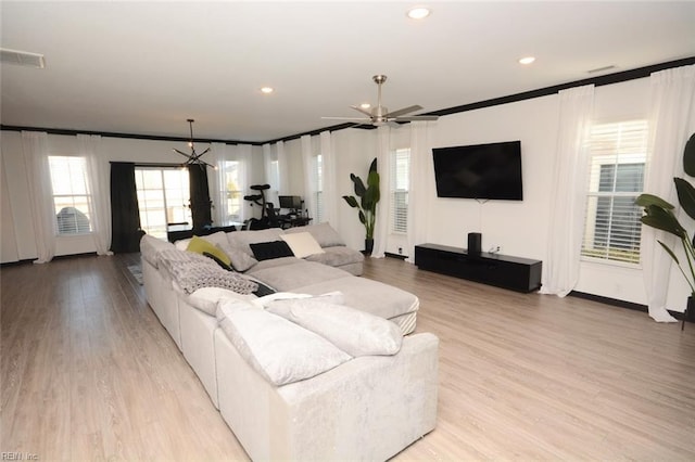 living room featuring light wood finished floors, visible vents, recessed lighting, and crown molding