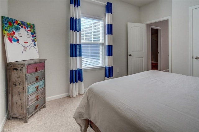 bedroom featuring light colored carpet and baseboards