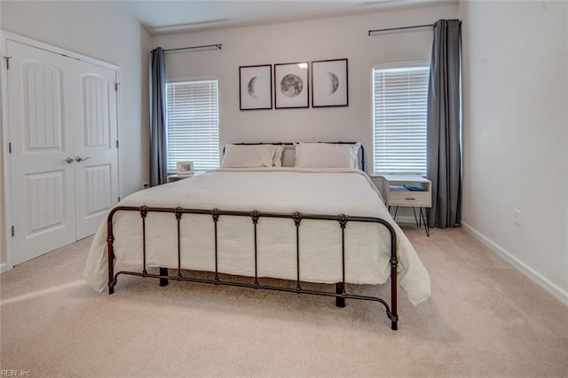 bedroom with light colored carpet and baseboards