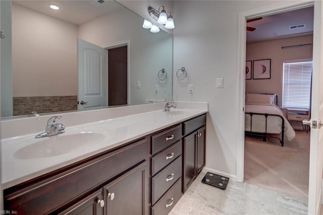 full bath featuring a sink, baseboards, ensuite bath, and double vanity