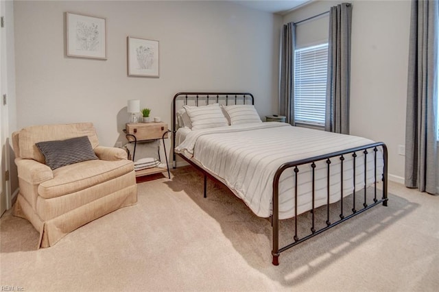 bedroom featuring light carpet and baseboards