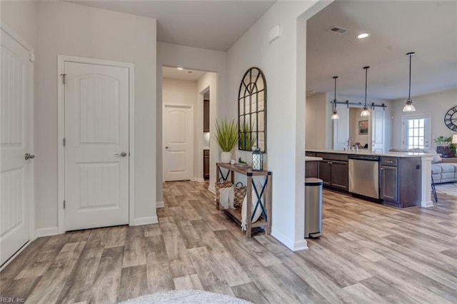 corridor with recessed lighting, visible vents, baseboards, and light wood finished floors