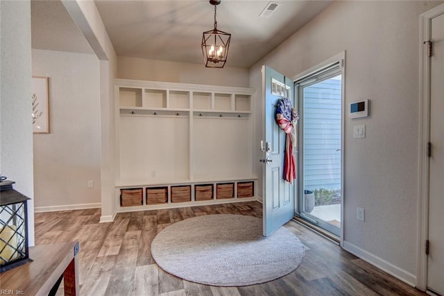 mudroom with visible vents, baseboards, wood finished floors, and a chandelier