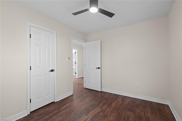 unfurnished bedroom featuring ceiling fan, dark wood-type flooring, and baseboards