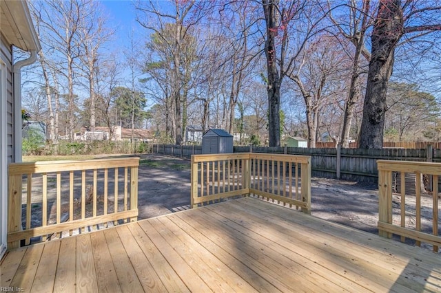 deck with an outbuilding, a storage unit, and a fenced backyard