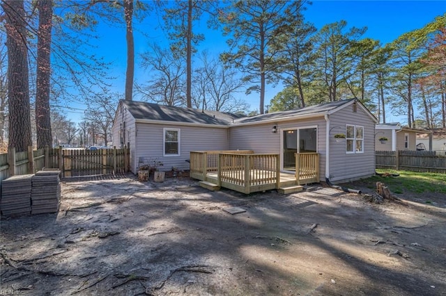 rear view of property featuring fence and a wooden deck