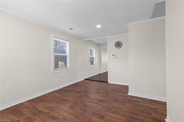 empty room featuring visible vents, crown molding, baseboards, dark wood finished floors, and recessed lighting