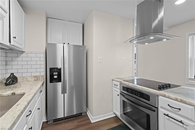 kitchen featuring island exhaust hood, dark wood finished floors, stainless steel appliances, white cabinets, and decorative backsplash