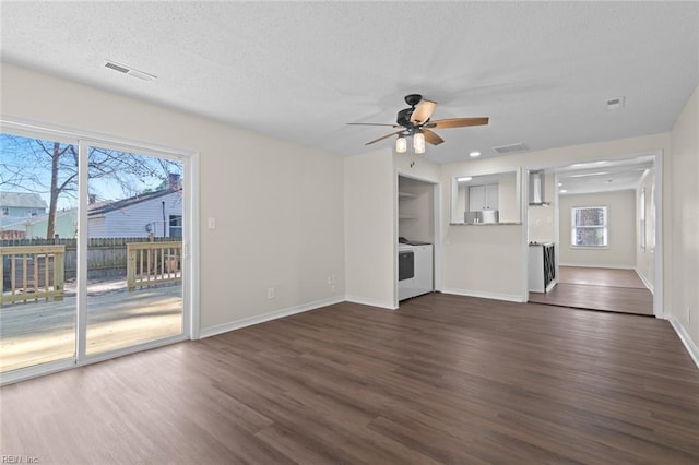 unfurnished living room with dark wood-type flooring, baseboards, and a textured ceiling