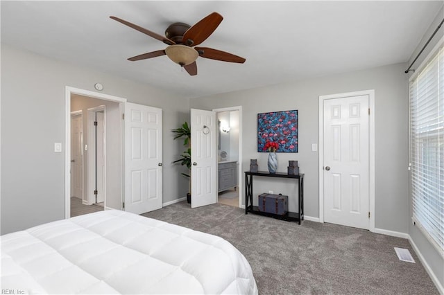 carpeted bedroom featuring a ceiling fan, baseboards, visible vents, and ensuite bathroom