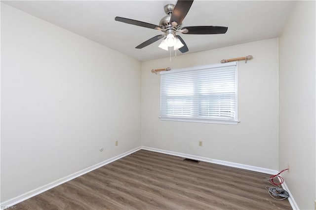 empty room featuring ceiling fan, baseboards, and wood finished floors