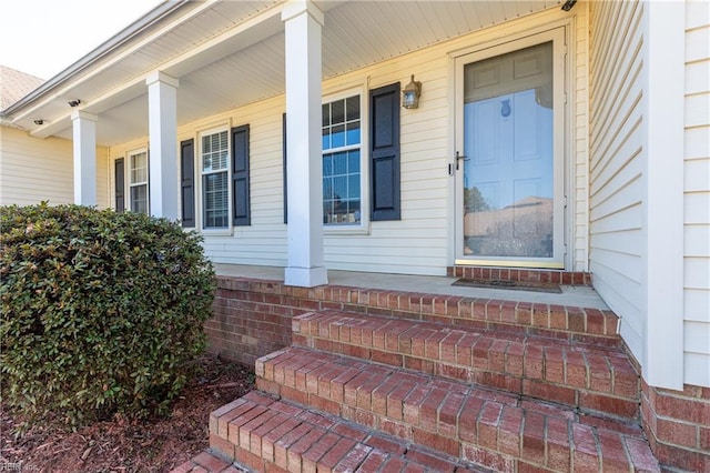 property entrance with brick siding and covered porch