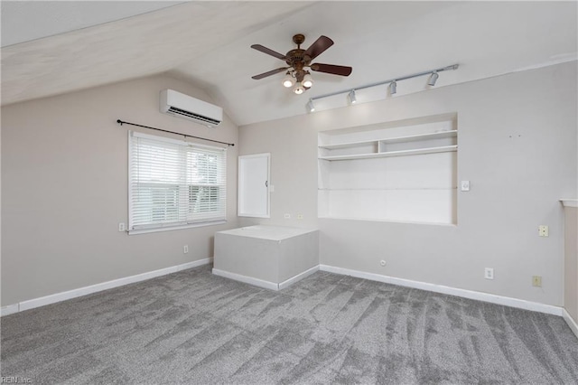 unfurnished bedroom with carpet flooring, a wall mounted AC, baseboards, and vaulted ceiling