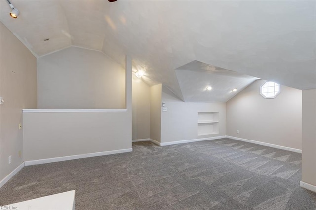 bonus room with baseboards, built in shelves, lofted ceiling, and carpet flooring