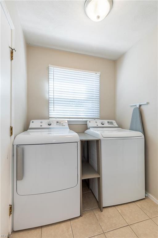 laundry room with laundry area, light tile patterned flooring, and washing machine and clothes dryer