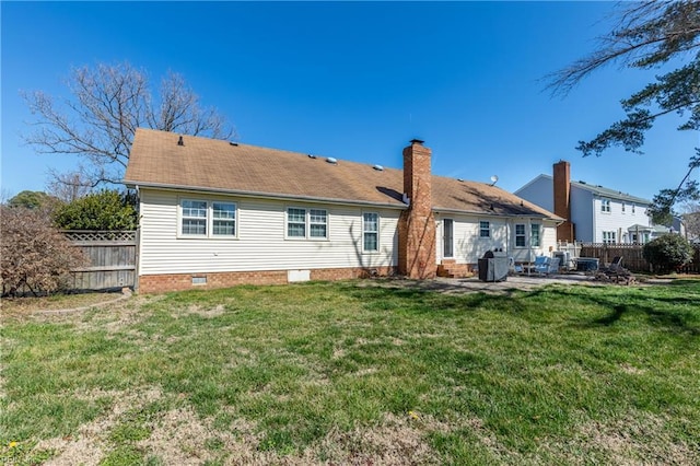 rear view of property featuring a patio area, a lawn, a chimney, and fence