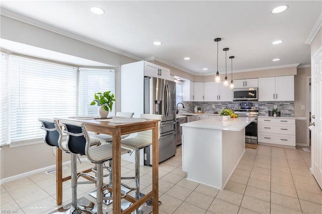 kitchen with ornamental molding, a sink, stainless steel appliances, light countertops, and light tile patterned floors