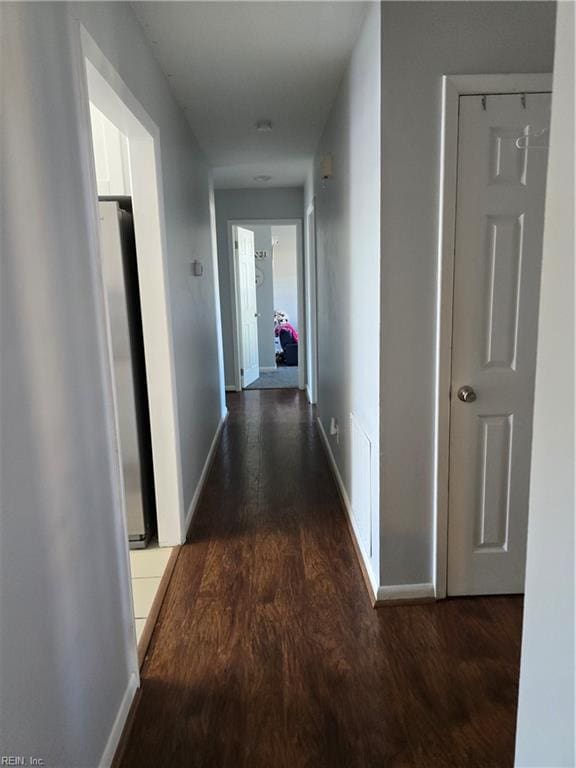 hallway featuring wood finished floors and baseboards