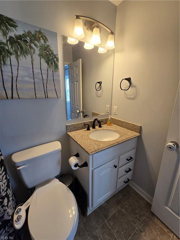 bathroom with tile patterned floors, baseboards, toilet, and vanity