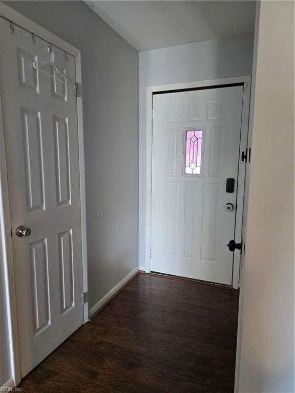 foyer entrance featuring dark wood finished floors and baseboards