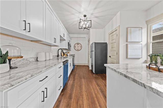 kitchen with a sink, dark wood-type flooring, appliances with stainless steel finishes, white cabinetry, and tasteful backsplash