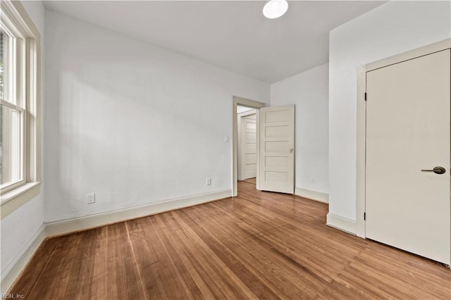 unfurnished bedroom with wood finished floors and baseboards