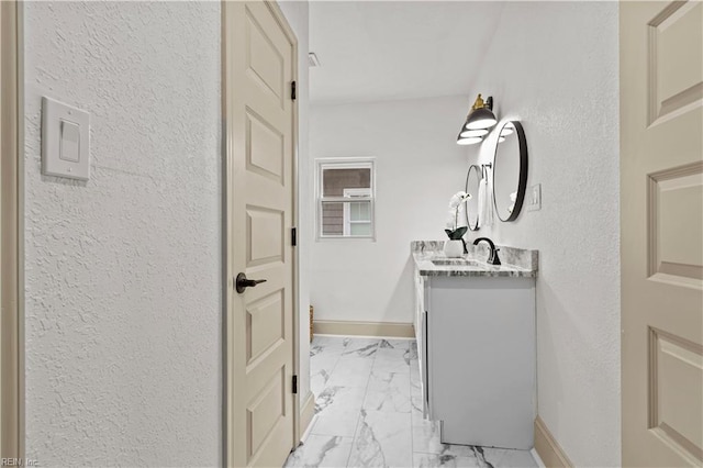 bathroom featuring vanity, baseboards, and marble finish floor