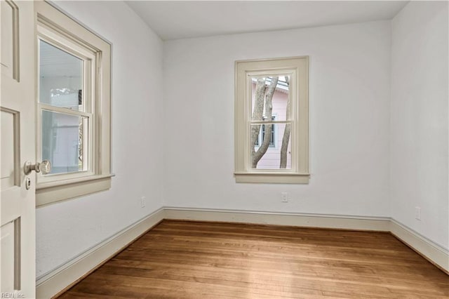 empty room featuring baseboards and wood finished floors