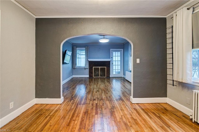 unfurnished living room featuring crown molding and a textured wall