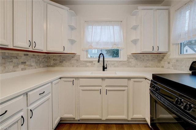 kitchen featuring open shelves, black stove, white cabinetry, and a sink