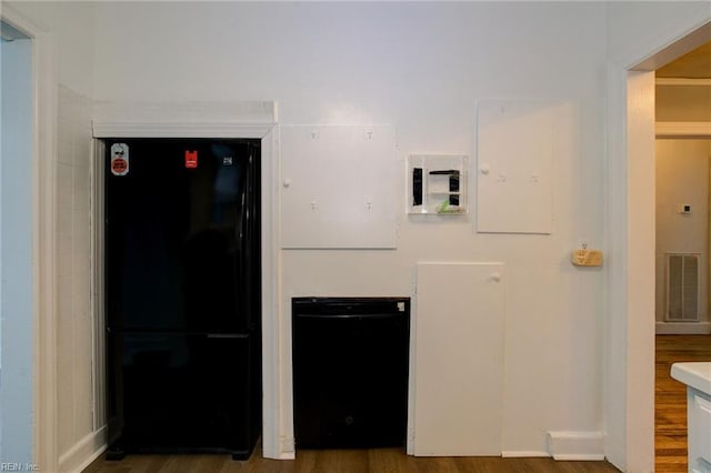 kitchen featuring wood finished floors, visible vents, and freestanding refrigerator