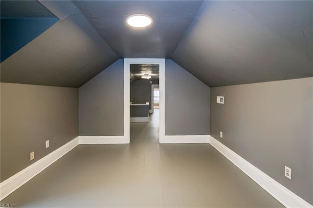 bonus room with baseboards and vaulted ceiling