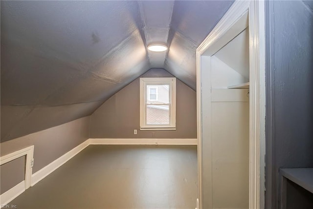 additional living space with baseboards and vaulted ceiling