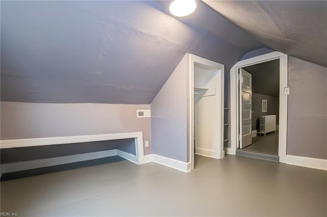 additional living space with visible vents, baseboards, radiator, and a textured ceiling