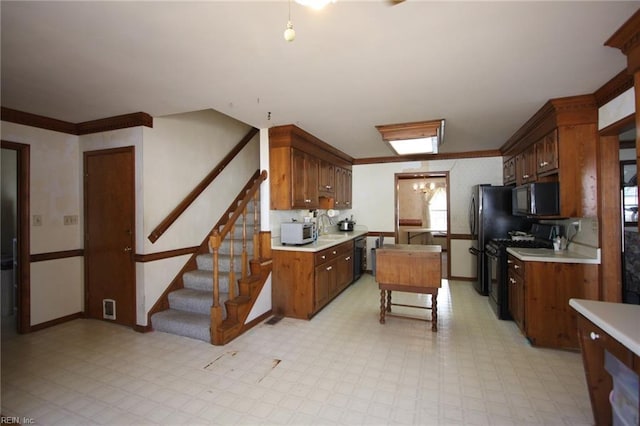 kitchen with gas stove, a notable chandelier, light floors, and light countertops