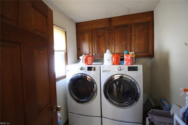 laundry area featuring washer and clothes dryer and cabinet space