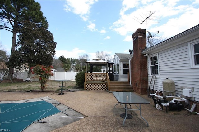 view of patio with a gazebo, fence, a fenced in pool, and a wooden deck