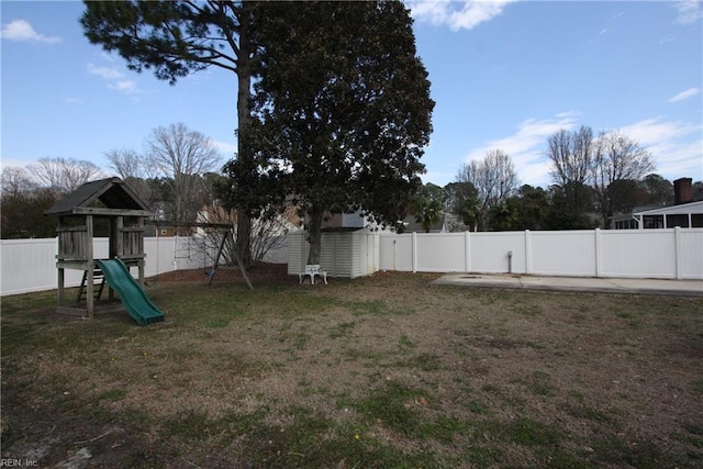 view of yard with a playground and a fenced backyard